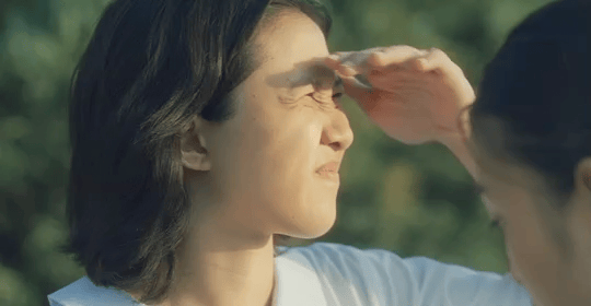 Ace shielding her eyes against the sun and glancing down at Jana